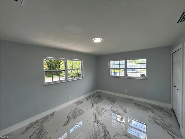 Tiled spare room with a wealth of natural light
