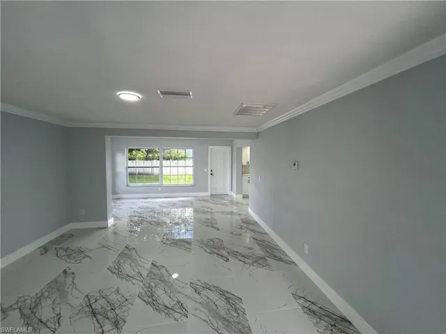 Unfurnished room with crown molding and light tile patterned floors