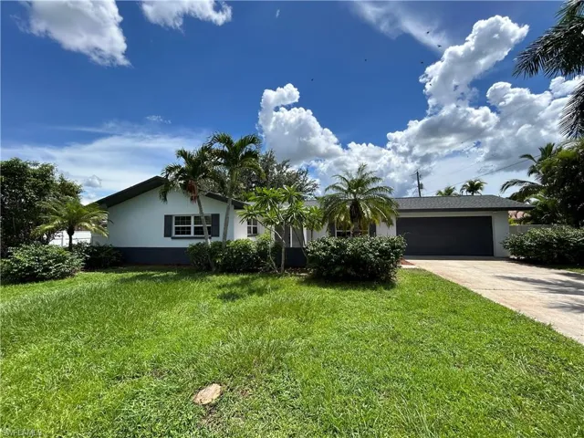 View of front of house with a garage and a front yard