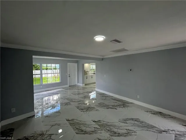 Unfurnished room featuring crown molding and tile patterned floors