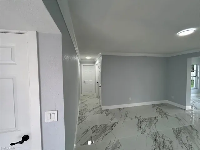 Tiled spare room with crown molding