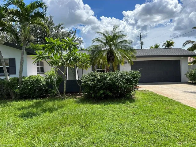 View of front of property featuring a garage and a front yard