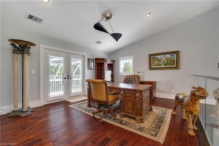 Loft office overlooking living room, located outside of master suite. Sliding doors open to balcony overlooking pool, golf course and Lake.