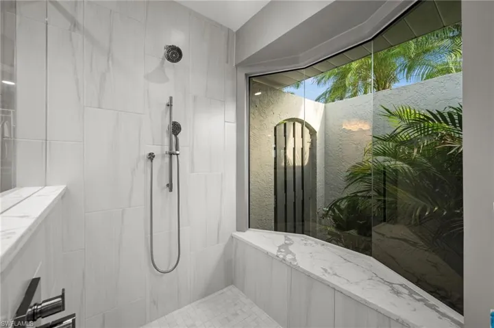 Walk-in shower with seamless enclosure and atrium  garden view