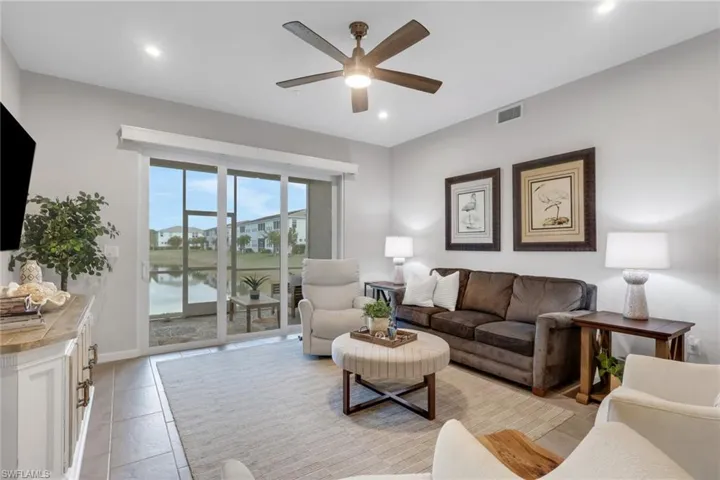 Living room with ceiling fan, recessed lighting, and a water view