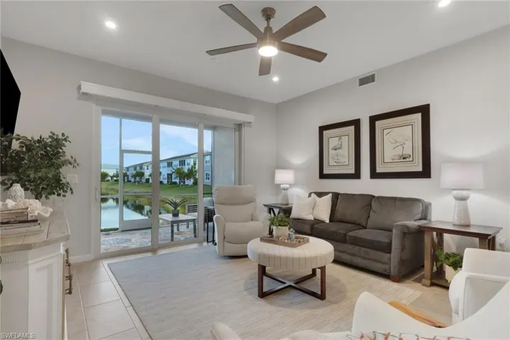 Living area with a ceiling fan, recessed lighting, and light tile patterned flooring