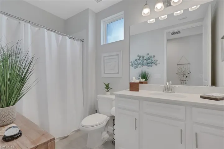 Bathroom with a shower with shower curtain, vanity, and light tile patterned floors