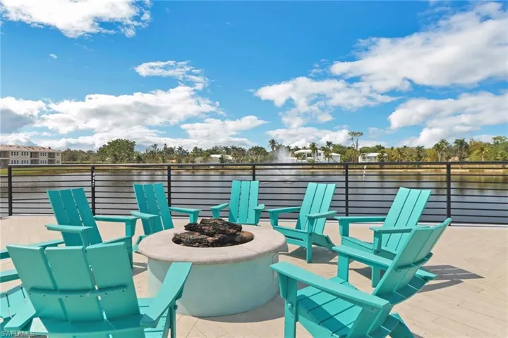 View of patio with a fire pit and a deck with water view