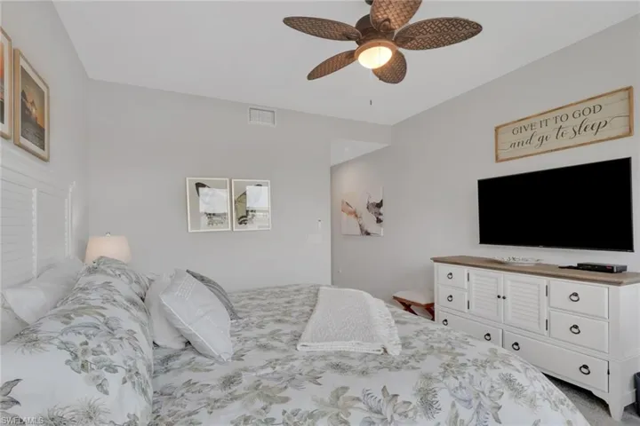 Carpeted bedroom featuring ceiling fan