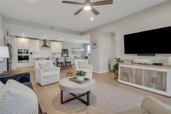 Living area with ceiling fan, recessed lighting, and light tile patterned flooring