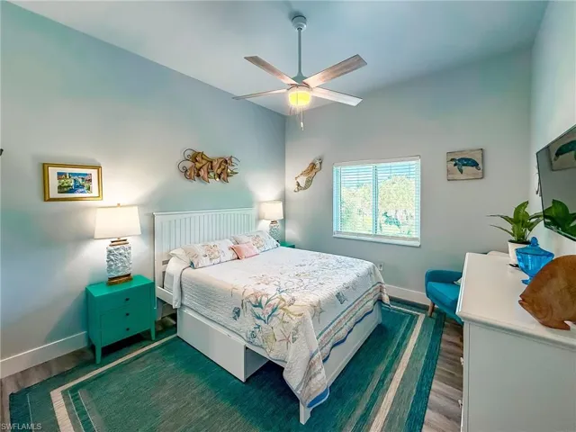Bedroom featuring wood finished floors, a closet, connected bathroom, and a ceiling fan