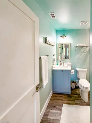Full bath featuring vanity, a shower stall, and dark wood-style floors