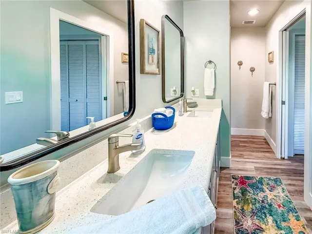 Laundry area featuring light wood-style flooring, washer and dryer, and cabinet space