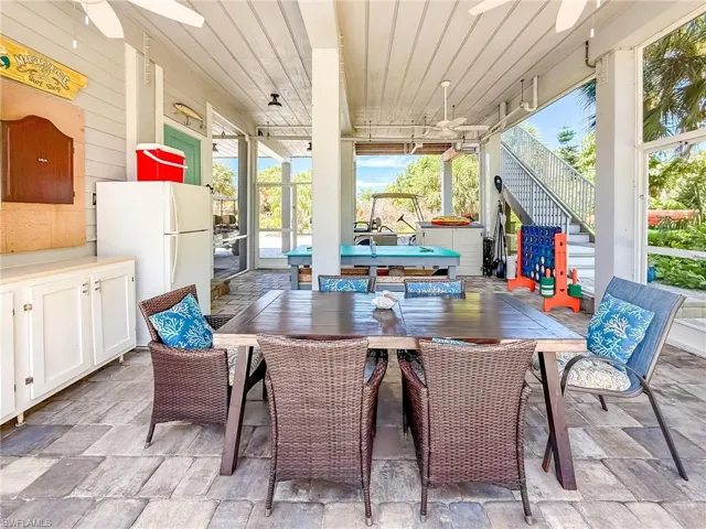 Wooden terrace featuring a ceiling fan and a view of trees