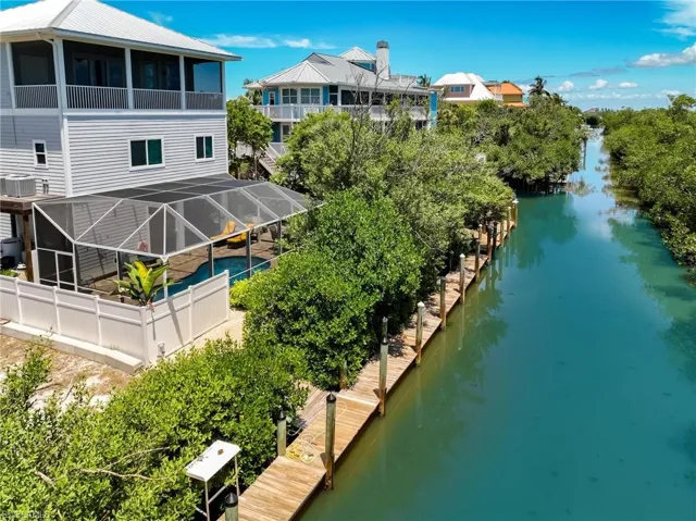 Rear view of property with a carport, a patio, and a balcony