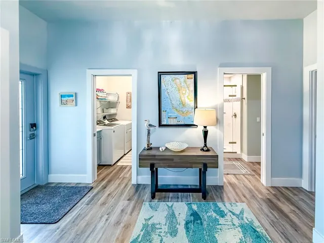Living area with ceiling fan, wood finished floors, and high vaulted ceiling