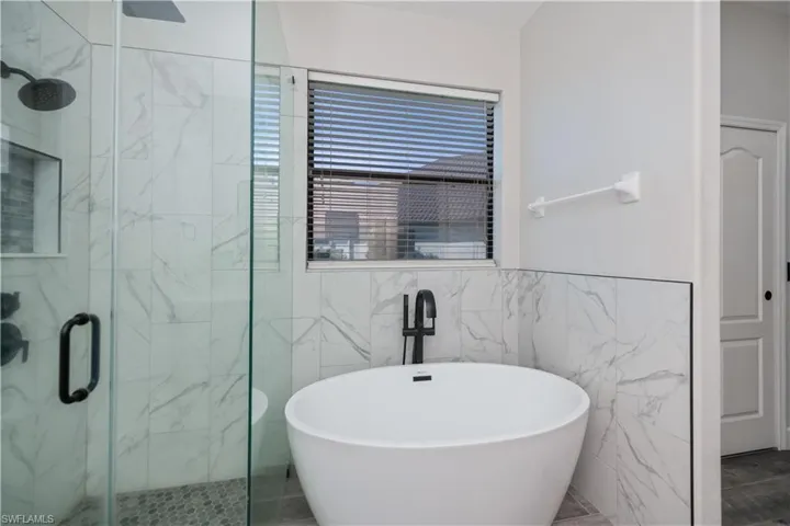 primary bathroom soaking tub an glass enclosed shower newly remodeled