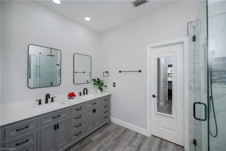 primary bathroom and door to walk in closet and glass enclosed shower