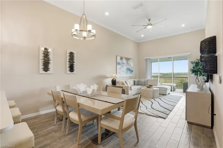 Dining space featuring wood finish floors, crown molding, ceiling fan, a chandelier, and recessed lighting