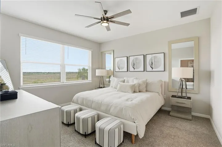 Carpeted bedroom featuring ceiling fan and baseboards