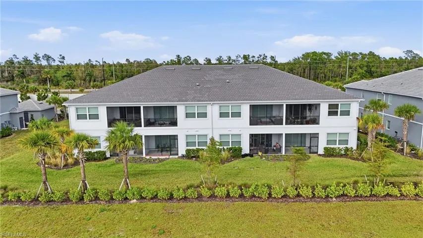 Back of house featuring a sunroom and a lawn