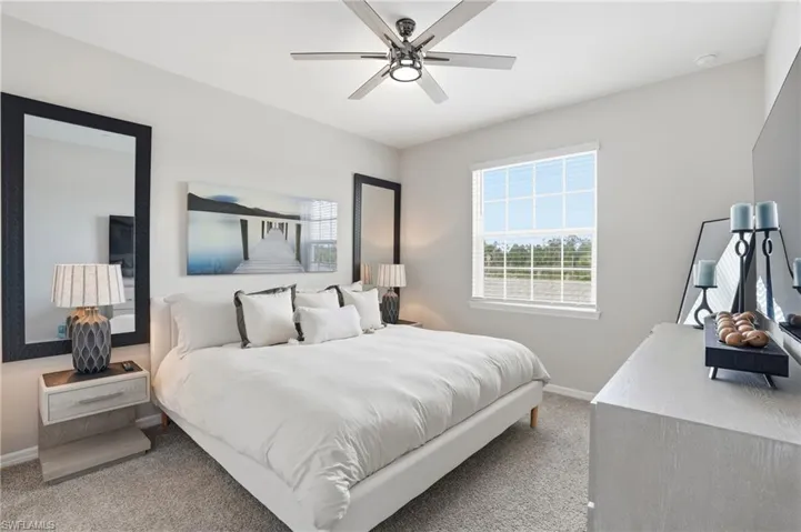 Carpeted bedroom featuring baseboards and a ceiling fan