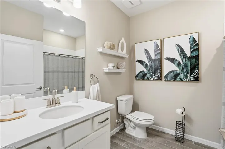 Full bath with vanity, a shower with shower curtain, and wood finish floors