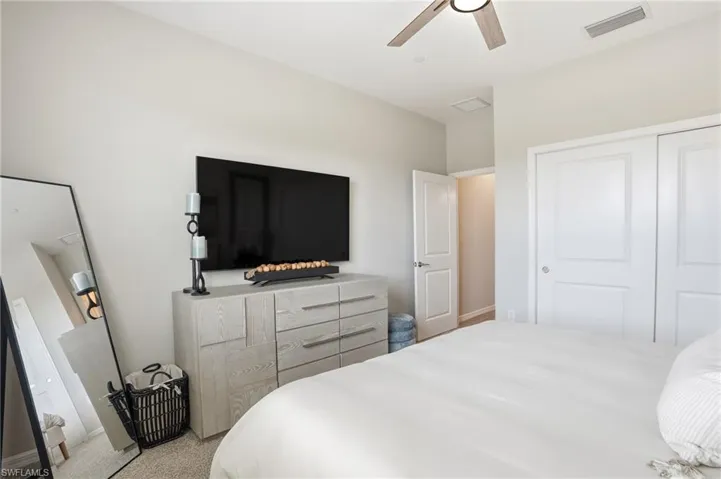 Bedroom with a closet, ceiling fan, and carpet floors