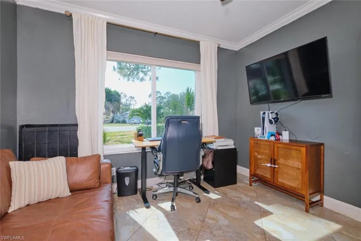 Home office featuring crown molding, large window for natural light