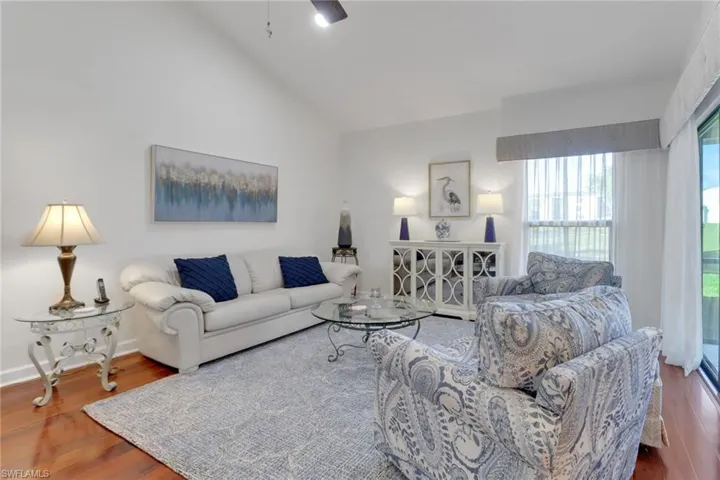 Living room with vaulted ceiling and hardwood / wood-style floors
