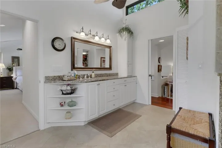 Bathroom featuring vanity, ceiling fan, and a high ceiling