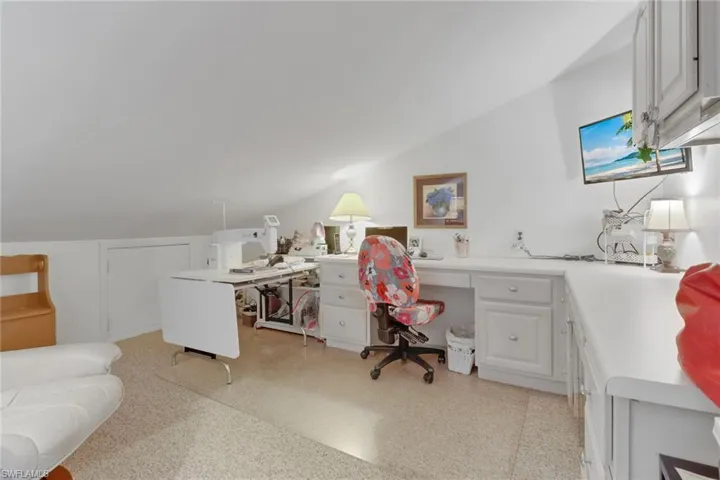 Office with built in desk and vaulted ceiling