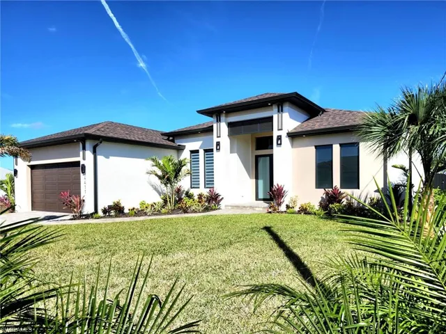 Prairie-style home with a garage and a front lawn