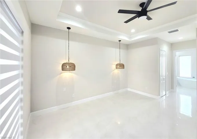 Spare room with a tray ceiling and ceiling fan