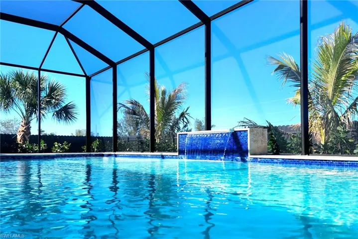View of swimming pool with a lanai and pool water feature