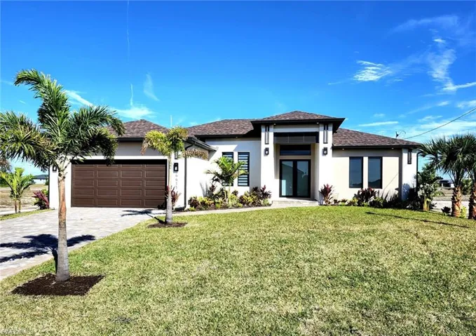 View of front of home featuring a garage and a front yard