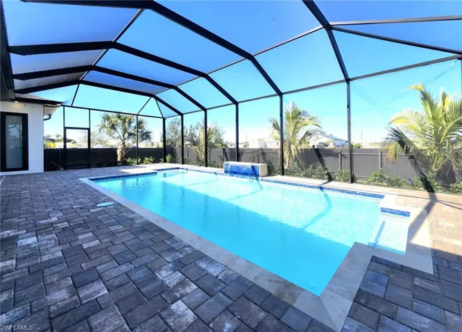 View of pool featuring a patio, pool water feature, and glass enclosure