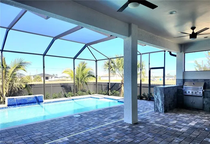 View of swimming pool with a lanai, ceiling fan, a grill, a patio area, and pool water feature