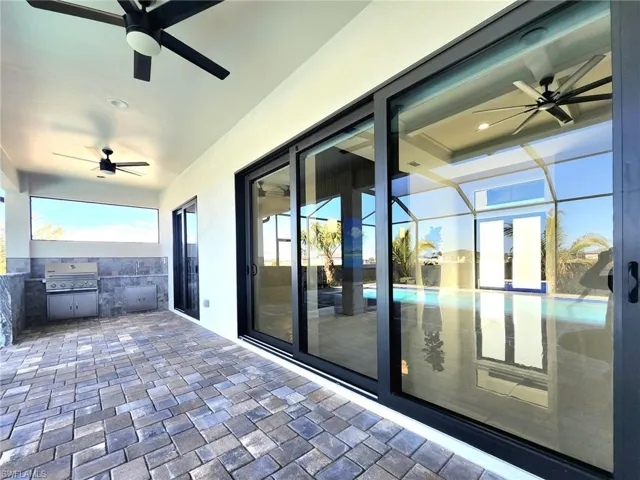 View of patio / terrace with an outdoor kitchen, area for grilling, and a lanai