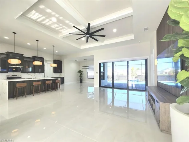 Living room with coffered ceiling, beam ceiling, and ceiling fan
