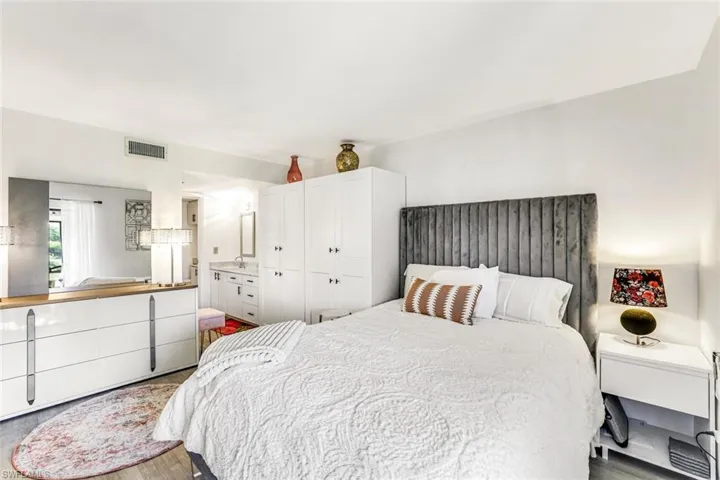 Bedroom with wood finished floors and ensuite bath