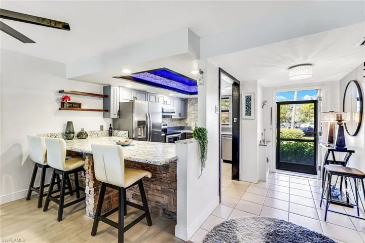 Kitchen with a breakfast bar, open shelves, stainless steel appliances, a peninsula, and ceiling fan