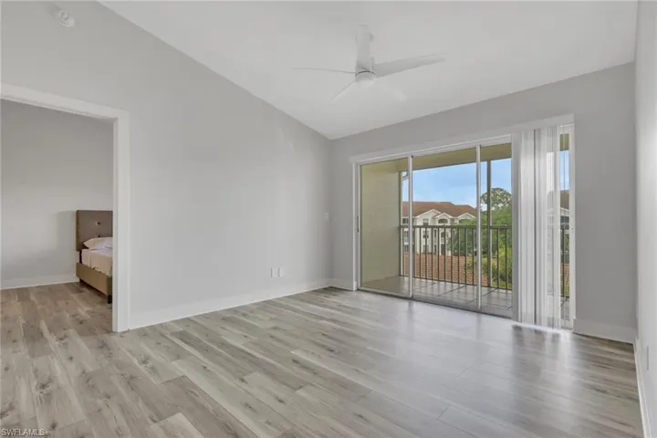 Empty room with lofted ceiling, a ceiling fan, and light wood-style floors