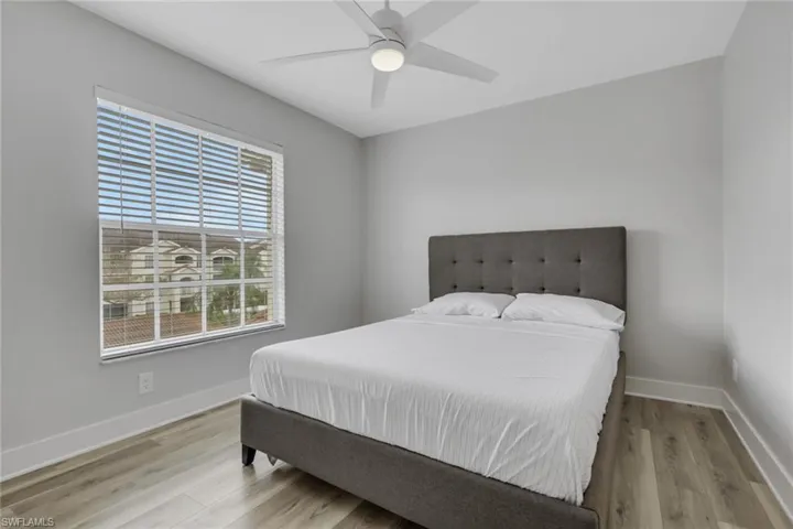 Guest bedroom with light wood-type flooring and a ceiling fan