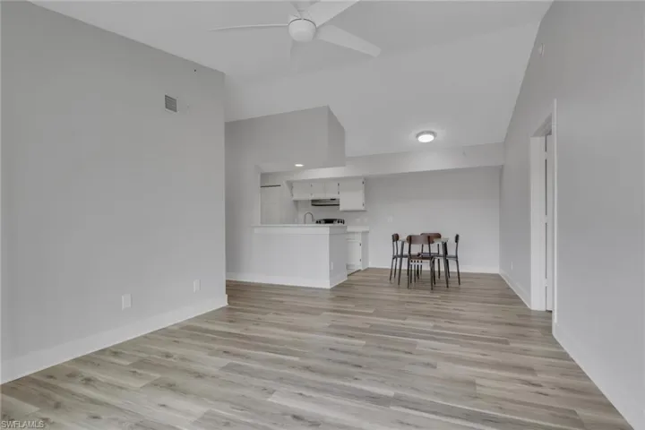 Living area featuring vaulted ceiling, a ceiling fan, and light wood finished floors