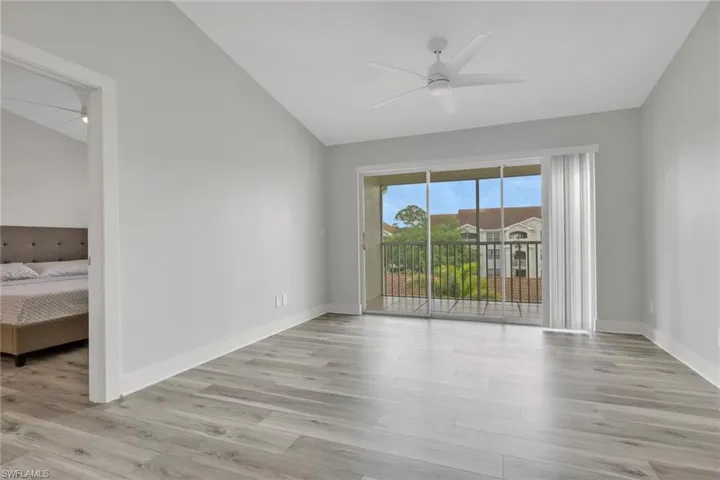 Unfurnished room featuring a ceiling fan, lofted ceiling, and light wood-type flooring