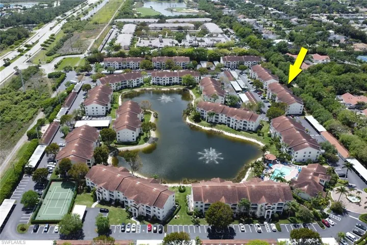 Aerial view of property's location featuring a large body of water and apartment complex