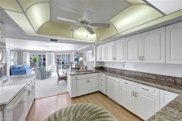 Kitchen featuring sink, white appliances, and white cabinetry