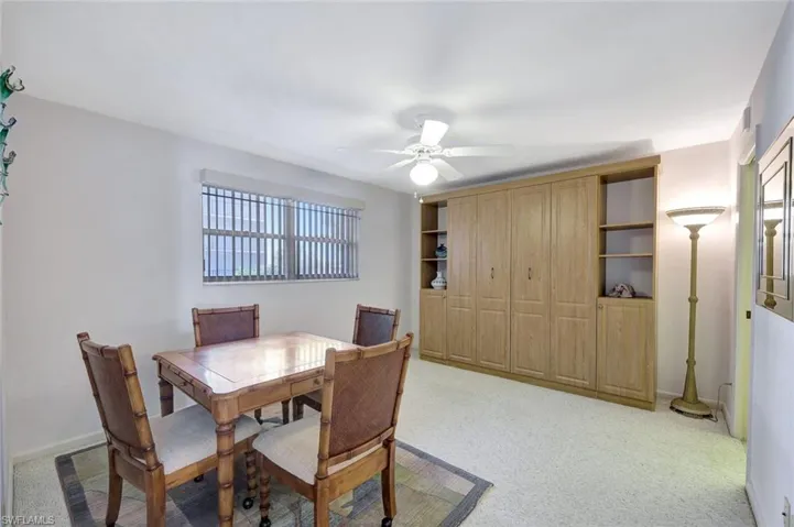 Dining space with light colored carpet and ceiling fan