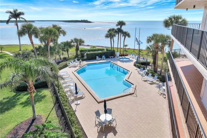 View of swimming pool featuring a patio area, a hot tub, and a water view
